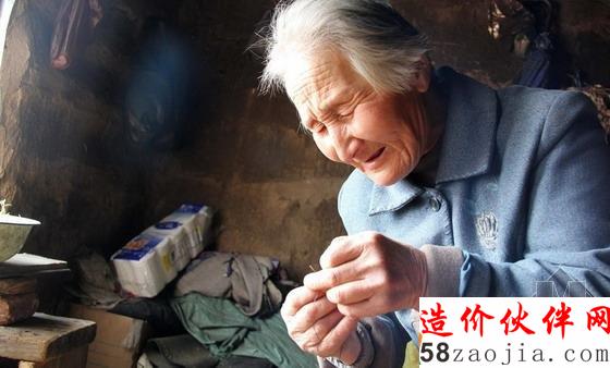 老人在舊土房的窗口借光穿針線